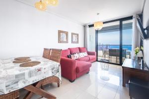 ein Wohnzimmer mit einem roten Sofa und einem Tisch in der Unterkunft Gemelos 26 Resort Apartment 27C Levante Beach in Benidorm