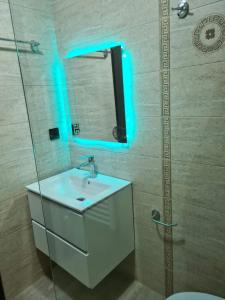 een badkamer met een witte wastafel en een spiegel bij Vila N&N Palace in Bistriţa Bîrgăului