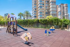 einen Spielplatz mit Rutsche und Spielgeräten in der Unterkunft Gemelos 26 Resort Apartment 27C Levante Beach in Benidorm
