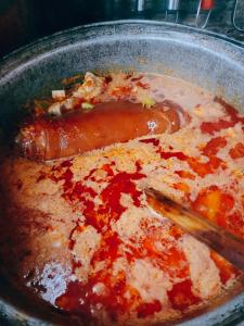 a pot of stew with a sausage and sauce at Vila N&N Palace in Bistriţa Bîrgăului