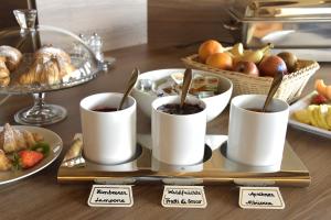 a tray with three cups of coffee on a table with food at Hotel Walder in Schenna
