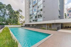 a swimming pool in front of a building at Flat Completo na Ponte Estaiada SP in Sao Paulo