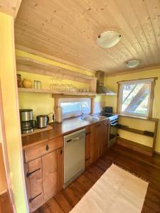 a small kitchen with wooden cabinets and a sink at Männiliiva puhkemaja in Hiiumaa