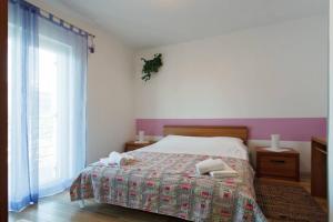 sypialnia z łóżkiem i dwoma ręcznikami na nim w obiekcie Komforan apartman 2+2 w Hvarze