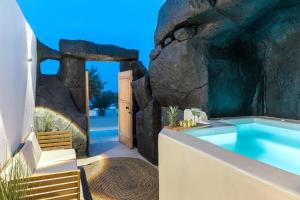 a hot tub in a rock wall next to a building at 23 Smart Suite by The Villa Collector in Imerovigli