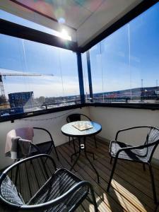 balcone con sedie, tavolo e alcune finestre di Beaivváš - luminous city home a Rovaniemi