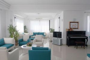 a living room with blue and white furniture and a piano at Bikini Hotel in Vieste