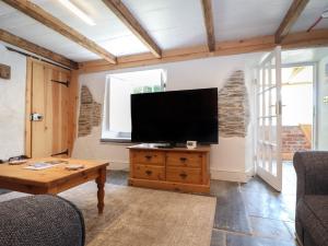 a living room with a flat screen tv on a wall at Trewince Manor Cottage in Truro