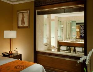 a hotel room with a large mirror and a bed at The Leela Palace Chennai in Chennai