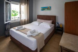 a bedroom with a large bed with towels on it at Olivemare Holidays in Nea Irakleia