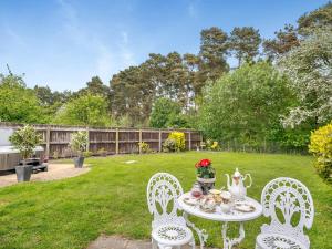 a table with a tea set on it in a yard at Pittendrigh Cottage in Briston