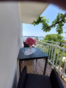 a table with a vase of flowers on a balcony at Apartments Vucetic in Hvar