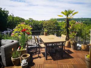 um deque de madeira com uma mesa e algumas plantas em Beautiful Rooftop between Paris and Versailles em Chaville