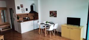 a kitchen with a table and chairs and a television at F 207 Primorsko del Sol - просторно студио с кухня in Primorsko +25 photos