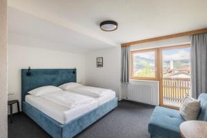 a bedroom with a bed and a large window at Rössle Appartement in Bezau