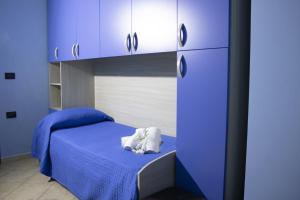 Schlafzimmer mit blauen Schränken und einem Bett mit blauer Bettwäsche in der Unterkunft Contedoro Living in Ariano Irpino