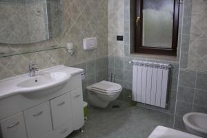 ein Badezimmer mit einem Waschbecken, einem WC und einem Spiegel in der Unterkunft Contedoro Living in Ariano Irpino