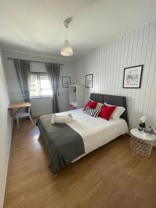 a bedroom with a large bed with red pillows at West Coast Peniche in Peniche