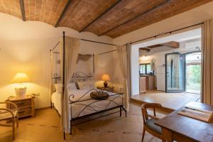 um quarto com uma cama de dossel e uma sala de jantar em Casale Rosmarino em Suvereto