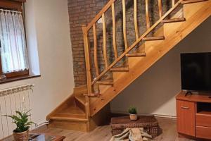 a living room with a wooden staircase with a tv at POSADA de BUSTIELLO,poblado minero de interés cultural in Mieres