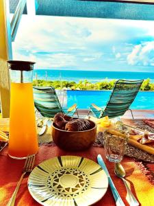 una mesa con un plato de comida y vistas al océano en La Villa By Ferdi'Nan, en Grand-Bourg