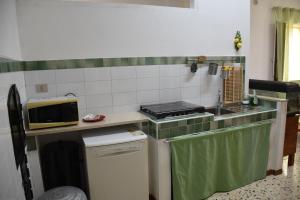 una pequeña cocina con fregadero y microondas en Casa Vacanze Adele, en Sciacca