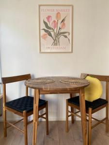 una mesa de madera y sillas con una foto en la pared en Beach Bliss, en Noordwijk