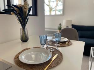 a table with plates and glasses on top of it at Studio calme proche Genève in Saint-Jean-de-Gonville