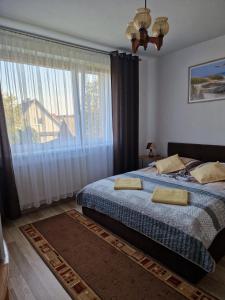 sypialnia z łóżkiem i dużym oknem w obiekcie RYNIO - Pokoje Gościnne w Łebie