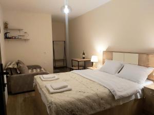 een slaapkamer met een groot bed en handdoeken bij Nitsa Guest House in Gori