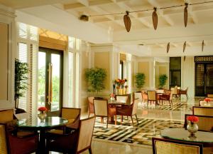 a lobby with tables and chairs in a building at The Leela Palace Chennai in Chennai