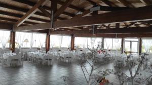 einen Bankettsaal mit weißen Tischen und Stühlen in der Unterkunft LA DARSENA rooms in Margherita di Savoia