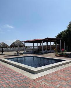 uma piscina no meio de um pátio com um pavilhão em Suites Playas em Data de Villamil