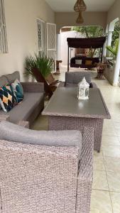 a living room with wicker furniture and a table at Villa Ngorè Saly in Saly Portudal