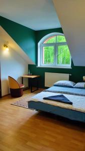a bedroom with a bed and a window and a table at Zajazd u Hermanów in Olsztyn