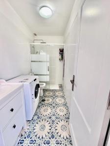 baño con lavadora y suelo de baldosa. en Alma 26, en Los Cancajos