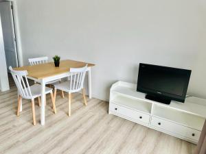 Un comedor con una mesa y un televisor. en Alma 26, en Los Cancajos