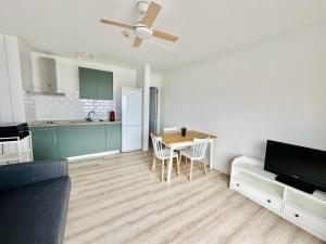 Una sala de estar con una mesa y una cocina. en Alma 26, en Los Cancajos