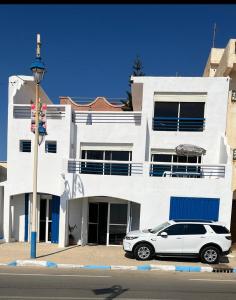 a white car parked in front of a white building at Azla beach in Azla