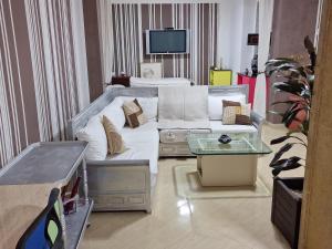ein Wohnzimmer mit einem weißen Sofa und einem TV in der Unterkunft Azla beach in Azla