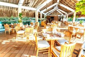un restaurante con mesas de madera y sillas en un patio en * * Magnífico * * apto en la playa * *Costazul 405, en Santa Marta