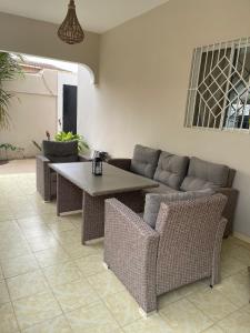 un soggiorno con divano, tavolo e sedie di Villa Ngorè Saly a Saly Portudal