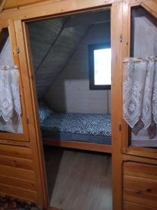 niewielka sypialnia z łóżkiem piętrowym i oknem w obiekcie Domek Dzięciołek w mieście Życiny