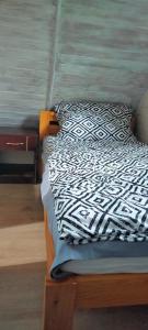 łóżko z czarno-białą kołdrą i poduszką w obiekcie Domek Dzięciołek w mieście Życiny