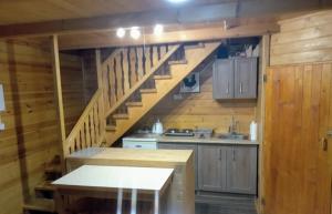 a kitchen with a staircase in a log cabin at Domek Dzięciołek in Życiny