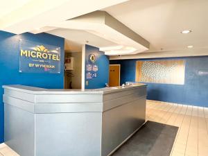 a lobby of a microsoft office with a reception counter at Microtel Inn by Wyndham Janesville in Janesville