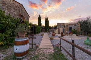 a garden with a wooden path and a building at Casale Rosmarino in Suvereto