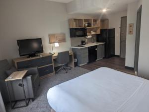 a bedroom with a bed and a desk with a television at Candlewood Suites Wilson, an IHG Hotel in Wilson