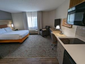 ein Hotelzimmer mit einem Bett und einem Flachbild-TV in der Unterkunft Candlewood Suites Wilson, an IHG Hotel in Wilson