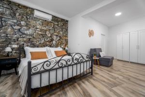 a bedroom with a stone wall and a bed at Villa Delmati in Tugare +42 photos
